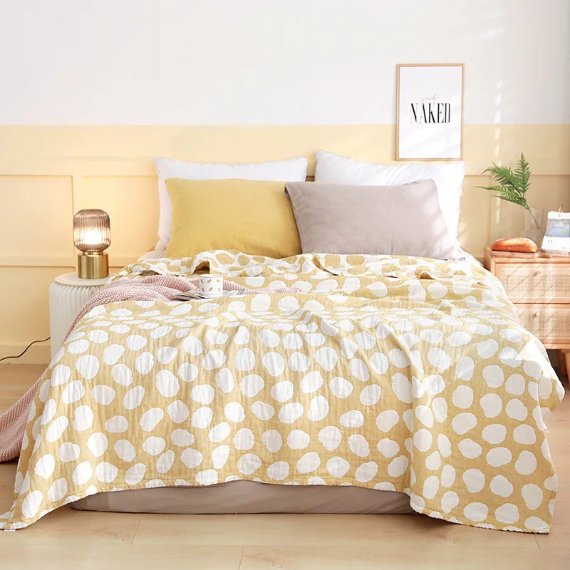 Bed with yellow polka dot comforter and pillows in a bedroom setting. Boho Lightweight microfiber summer blanket for bed or sofa, cooling breathable throw for home, dorm, or office naps with geometric jacquard pattern.
