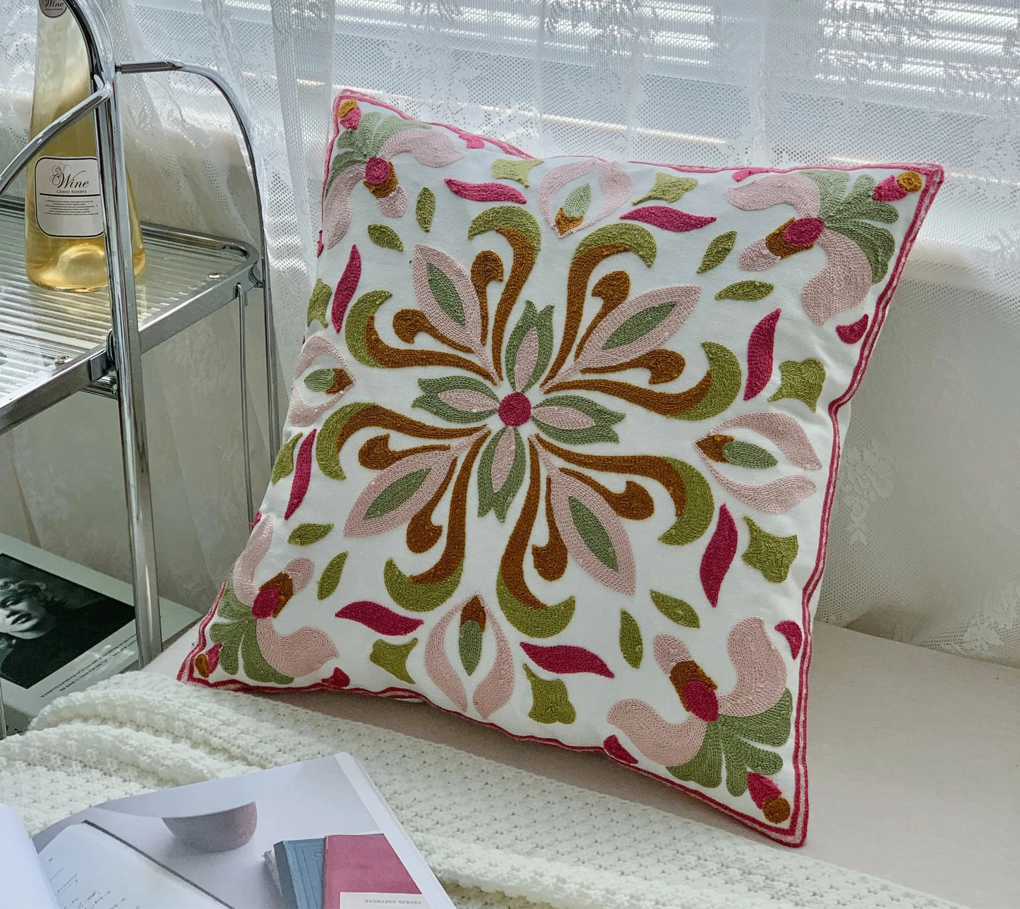 Decorative pillow with floral pattern on a couch next to a bottle of wine. floral embroidery on linen cotton cushion cover – boho home decor accent