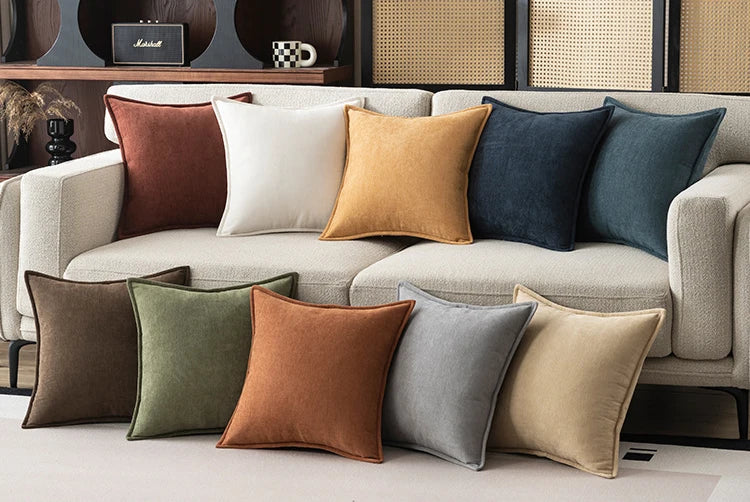 Colorful pillows on a beige sofa with a neutral background