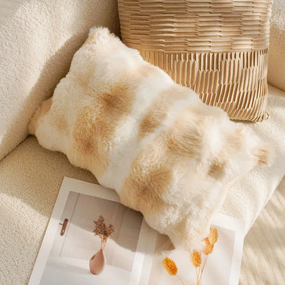 Fluffy pillow on a couch with a magazine and decorative items.