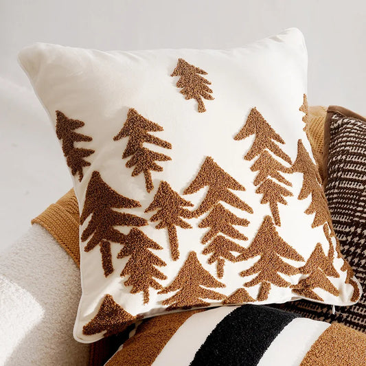 Decorative pillow with brown tree patterns on a neutral background