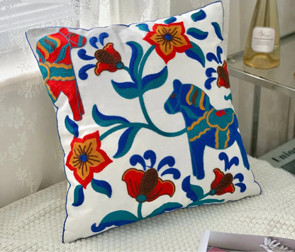 Decorative pillow with floral and horse design on a white background, featuring the brand Handcrafted embroidered cushion cover on armchair – modern boho living room decor