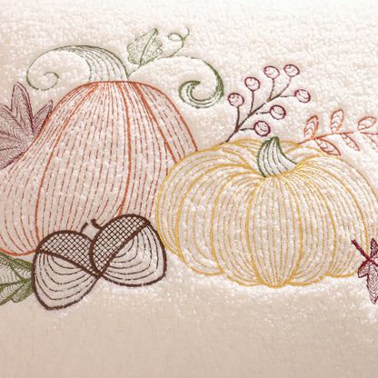 Embroidered design of pumpkins and leaves on a textured beige background. fall boho pillow throw gift ideas