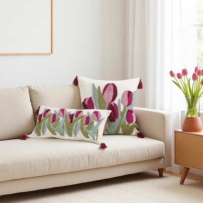 Decorative pillows with floral pattern on a beige sofa in a bright living room.