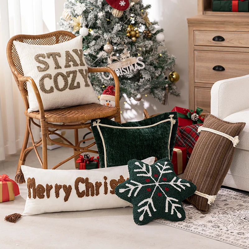 Decorative pillows with Christmas-themed text and a Christmas tree in the background