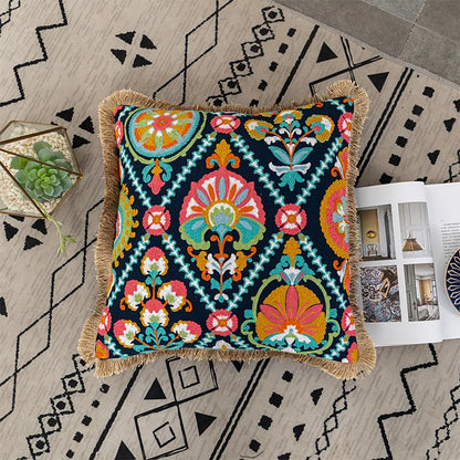 Decorative pillow with colorful pattern on a geometrically patterned rug. Bohemian embroidered throw pillow cover with geometric design, cotton-blend cushion for sofa, bed, or modern home decor.