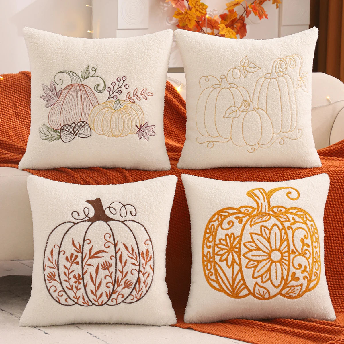 Four decorative pillows with pumpkin patterns on a couch. fall boho pillow throw gift ideas