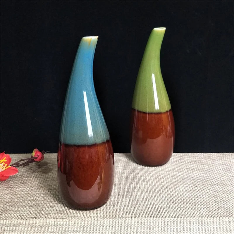 Two boho ceramic vases with multicolored glaze on a textured surface with a dark background