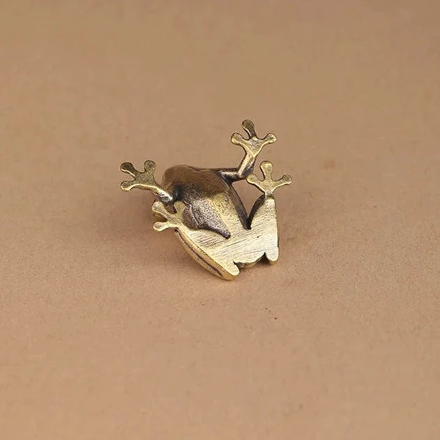 Bronze frog sculpture on a beige background 