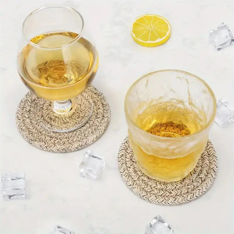 Two glasses of yellow liquid on woven coasters with lemon slices and ice cubes on a light background Set of cotton drink coasters – eco-friendly housewarming gift idea
