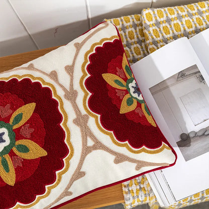 Decorative rug with floral patterns on a wooden surface. Bohemian embroidered throw pillow cover with geometric design, cotton-blend cushion for sofa, bed, or modern home decor.