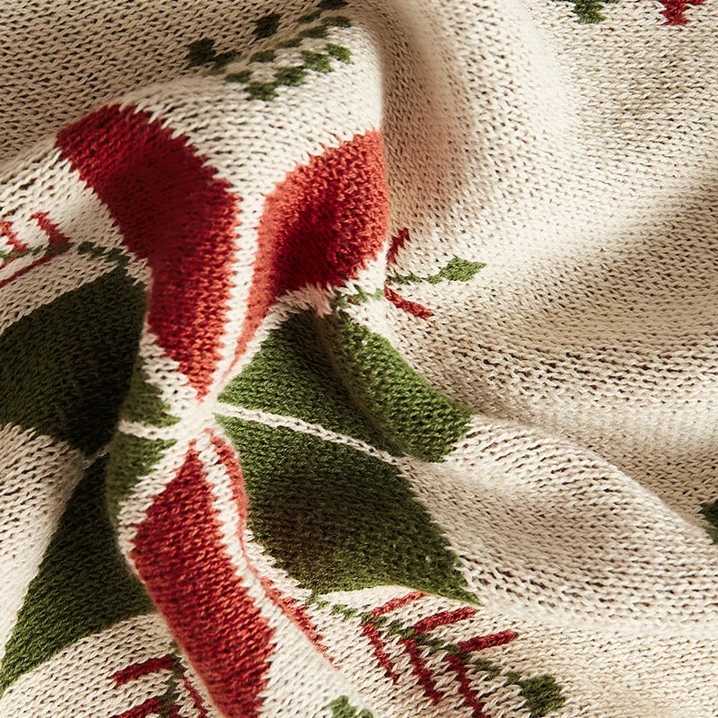 Close-up of a knitted fabric with red and green patterns on a beige background