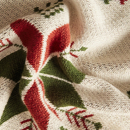 Close-up of a knitted fabric with red and green patterns on a beige background