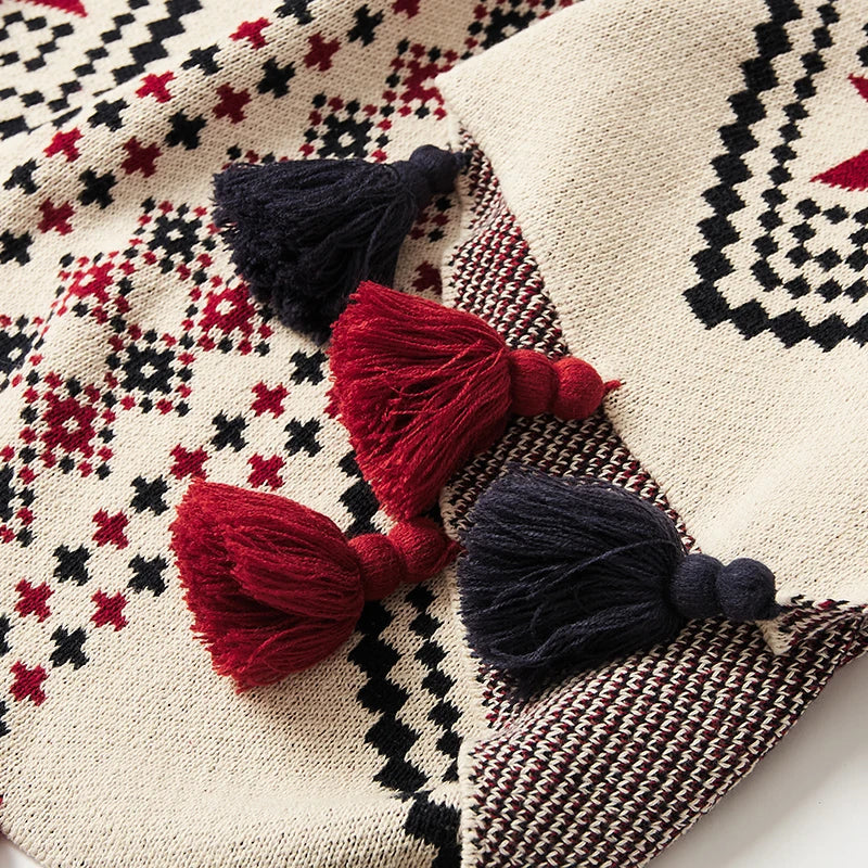 Decorative pillows with tassels on a patterned fabric background