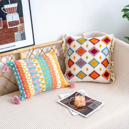 Decorative pillows on a couch with a magazine and framed artwork in the background.