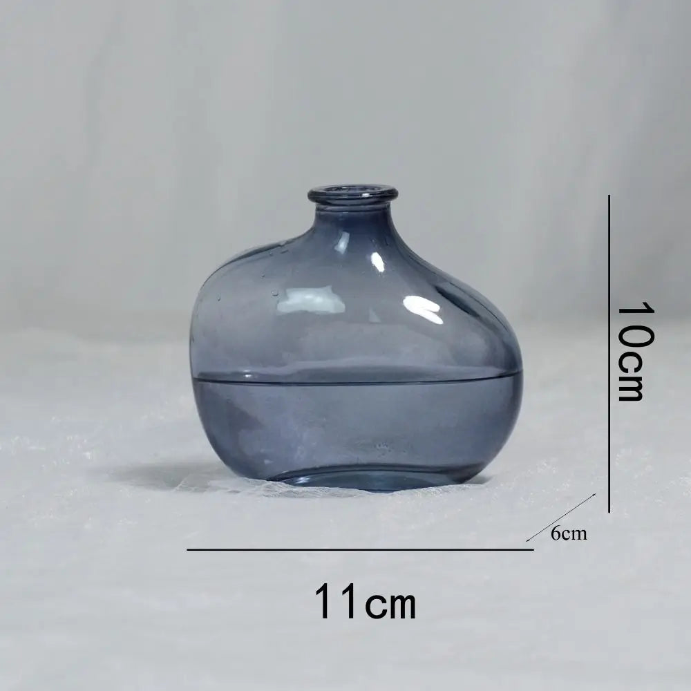 Blue glass vase with measurements on a gray background