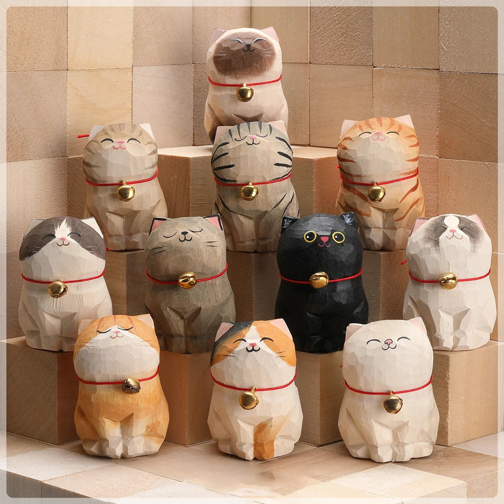 Collection of cat-shaped decorative items with bell collars on a tiled floor.