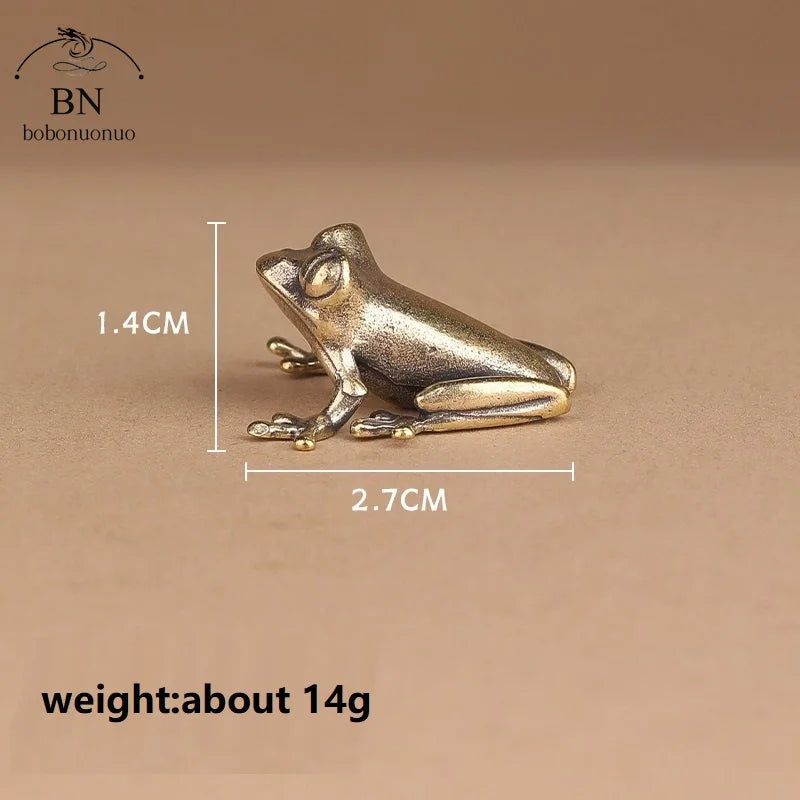 Bronze frog figurine with measurements on a brown background