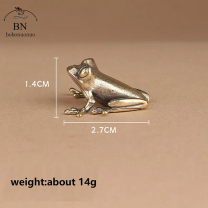 Bronze frog figurine with measurements on a brown background