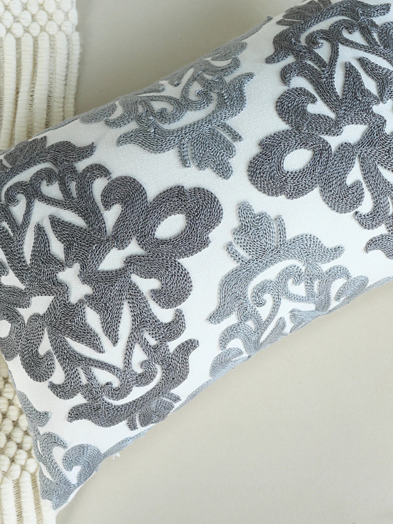Decorative pillow with intricate black pattern on a light background