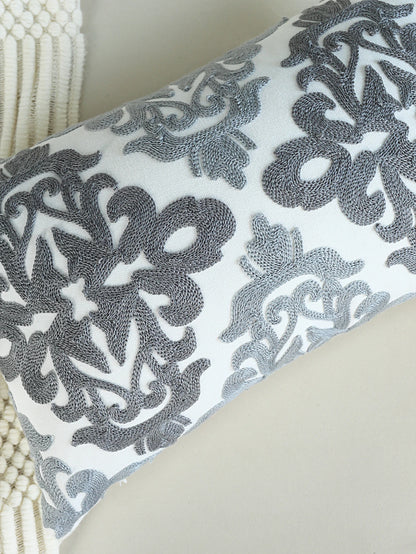 Decorative pillow with intricate black pattern on a light background