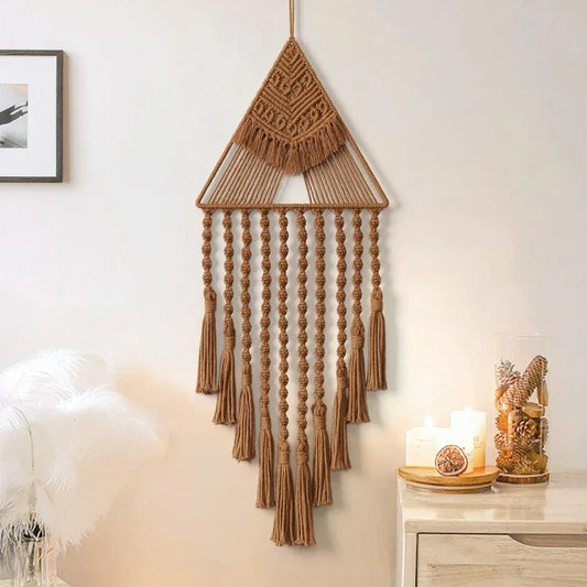Macrame wall hanging with tassels on a neutral wall with candles and decor. boho home decor, macrame wall hanging, triangle dream catcher, woven tapestry, handmade cotton wall decor, tassel wall hanging, bedroom door decor, housewarming gift, rustic bohemian art, boho apartment wall decor, neutral textile art