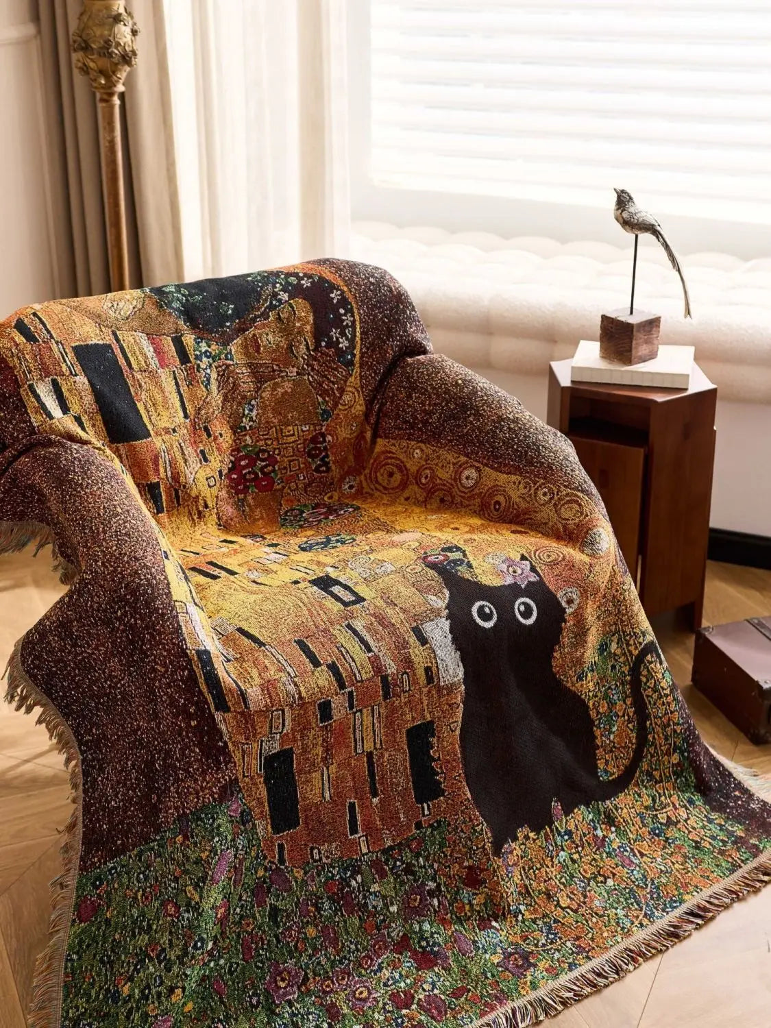 Decorative blanket with a cat design draped over a chair in a room. Cat woven throw blanket for boho sofa and home decor