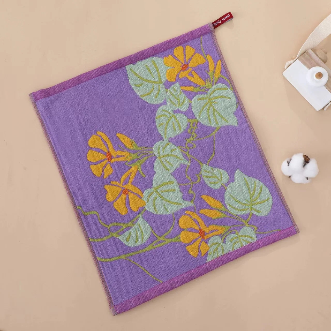 Floral-patterned tea towel on a beige surface