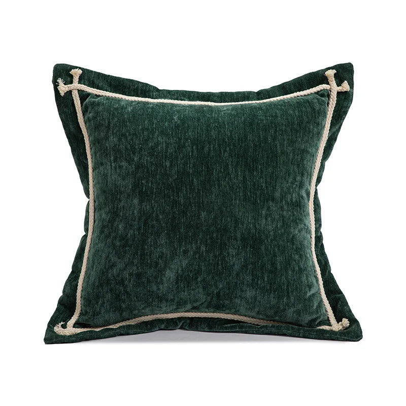 Green velvet pillow with beige trim on a white background