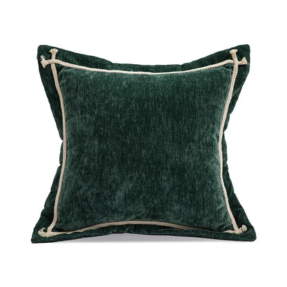 Green velvet pillow with beige trim on a white background