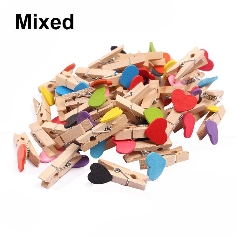 Assorted wooden clothespins with colorful heart-shaped clips on a white background