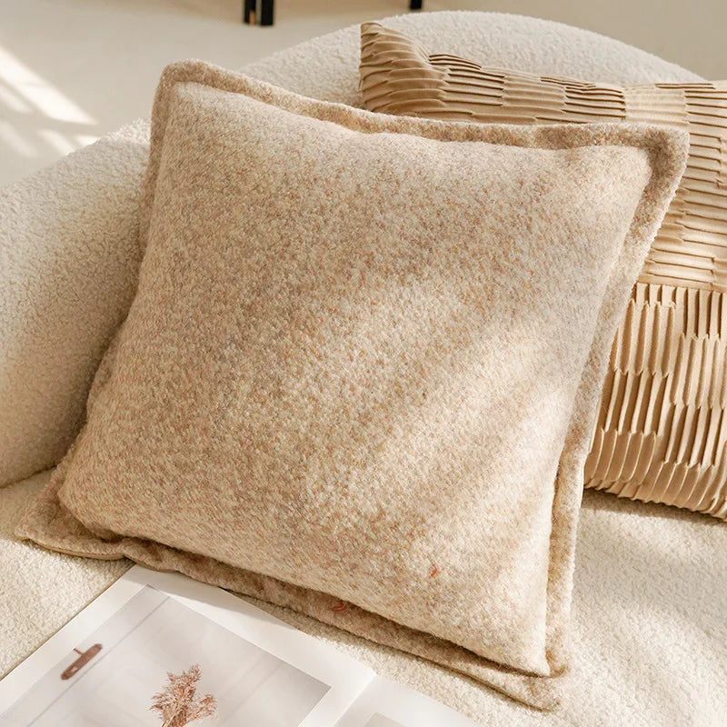 Beige textured pillow on a couch with a woven basket in the background