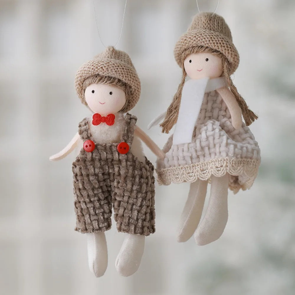 Two handmade dolls, one in a boy outfit with a red bow tie and the other in a girl outfit with a dress, against a blurred background.