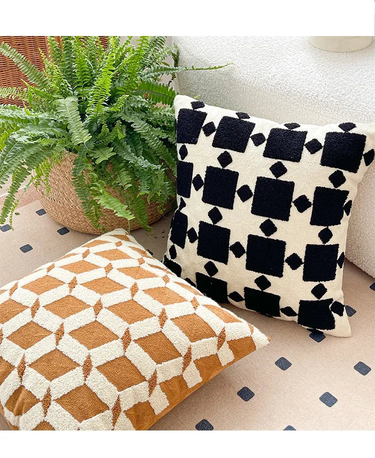 Two patterned pillows on a couch with a plant in the background. Bohemian embroidered throw pillow cover 18x18 inch with geometric towel embroidery, decorative cushion for sofa, bed, or living room boho home decor