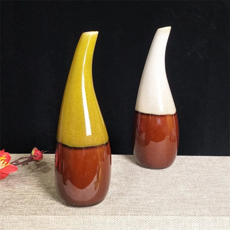 Two boho mini ceramic vases with colorful glaze on a textured surface with a dark background