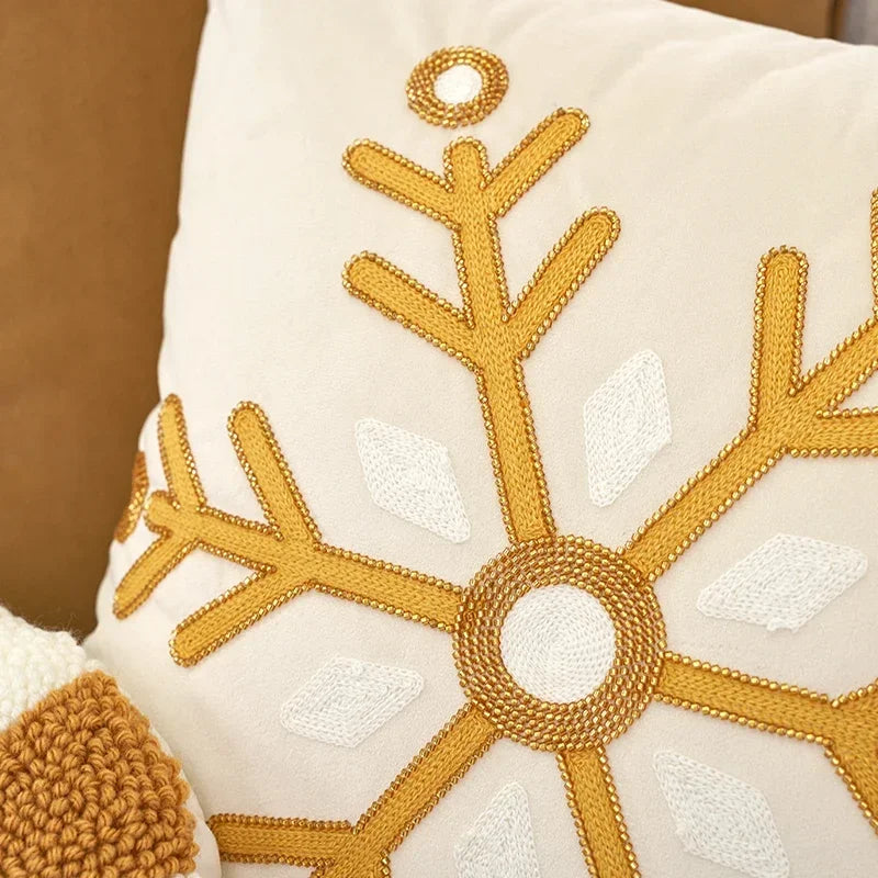 Decorative pillow with gold beaded snowflake pattern on a beige background