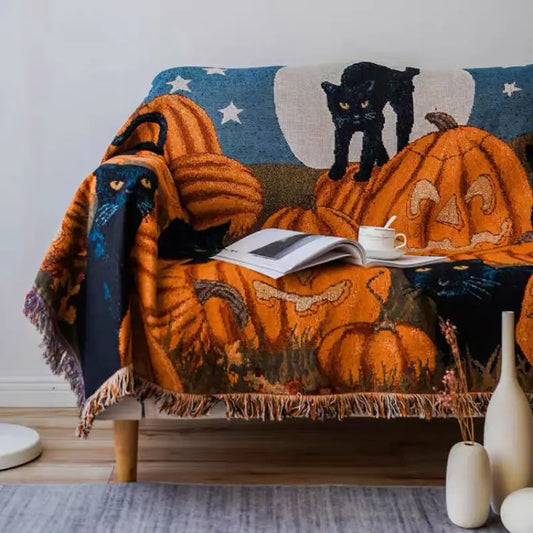 Decorative blanket with Halloween-themed design on a couch, featuring pumpkins and cats. Halloween black cat and pumpkin throw blanket, woven spooky tapestry for autumn decor