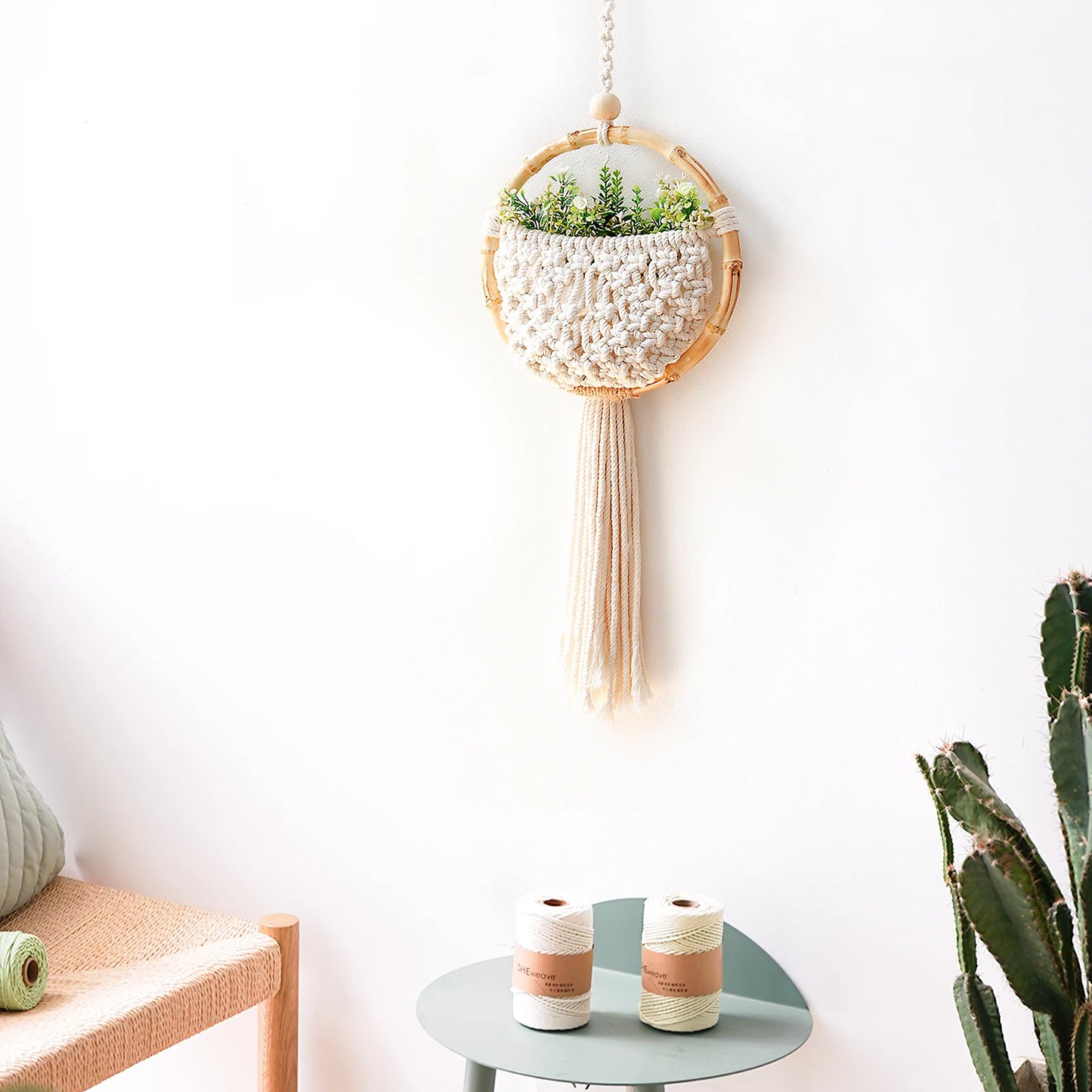 Hanging plant holder with decorative elements on a white wall