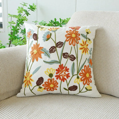 Floral-patterned pillow on a beige couch with plants in the background. Floral embroidered throw pillow cover boho decor