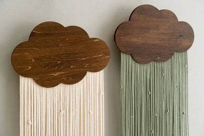Two cloud-shaped wooden wall hangings with string art on a plain background