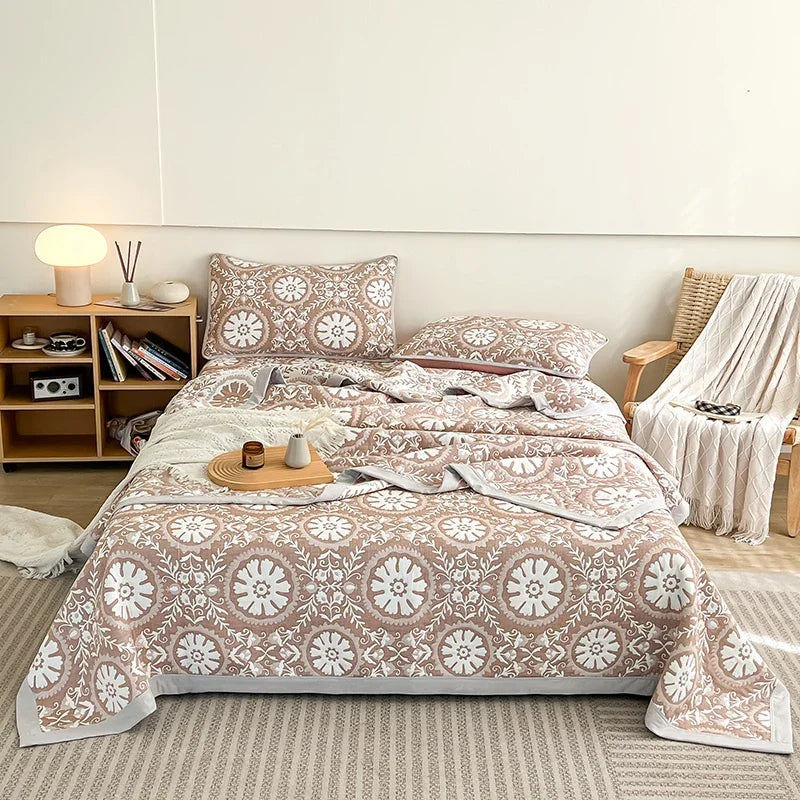 Bed with patterned bedding in a room with a bookshelf and chair. Boho breathable lightweight summer spring fall blanket quilt bedspread 