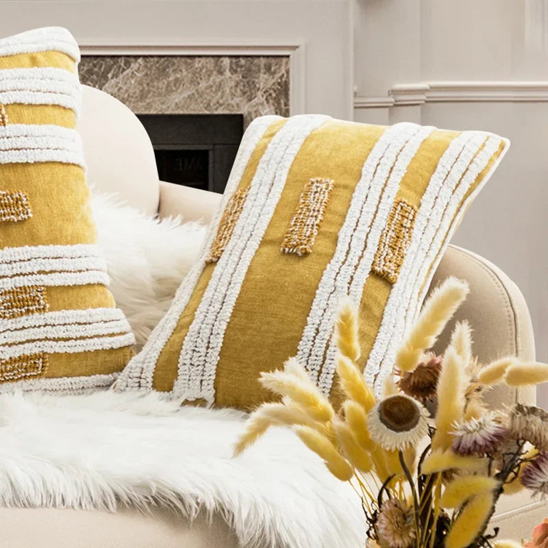 Decorative pillows with yellow and white patterns on a couch in a living room setting. Nordic blue tufted cushion cover with geometric stripe and grid crochet pattern, tassel pillow cover for sofa, bed, and boho home decor