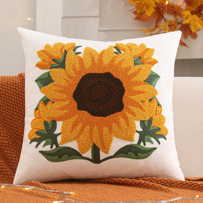 Decorative pillow with sunflower design on a couch. Velvet pillow cover with embroidered pumpkins, sunflowers, and autumn leaves – cozy fall home décor for sofa or living room.