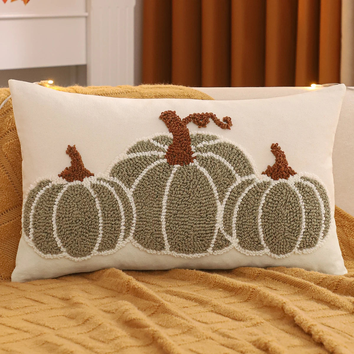Decorative pillow with pumpkin design on a couch. Festive fall pillow cover for Halloween and Thanksgiving décor