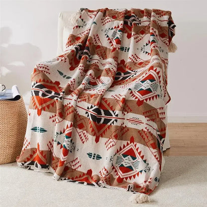 Decorative Bohemian blanket with geometric pattern draped over a chair in a room.