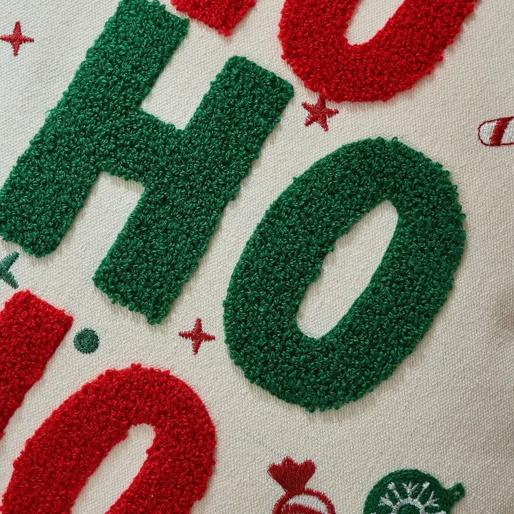 Close-up of a textured fabric with 'HO HO HO' text in green and red on a white background.