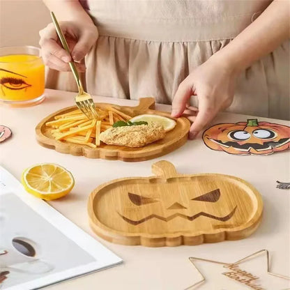 Person using a wooden pumpkin-shaped tray with food on a table.  Wooden Halloween serving tray in pumpkin and ghost shapes, rustic snack and dessert plate for party décor and fall entertaining