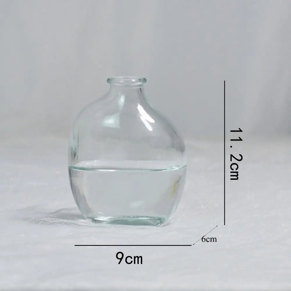 Clear glass vase with dimensions labeled on a gray background