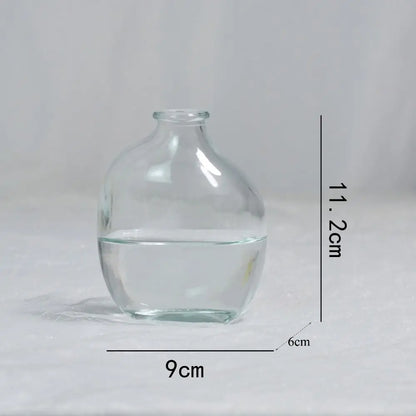 Clear glass vase with dimensions labeled on a gray background