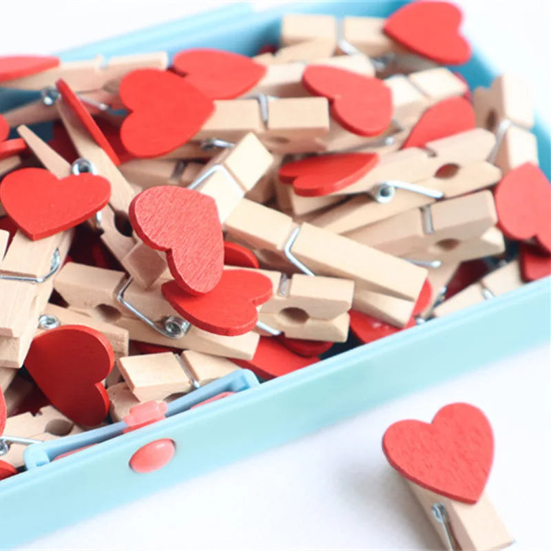 Heart-shaped wooden clips with red and beige colors in a container.